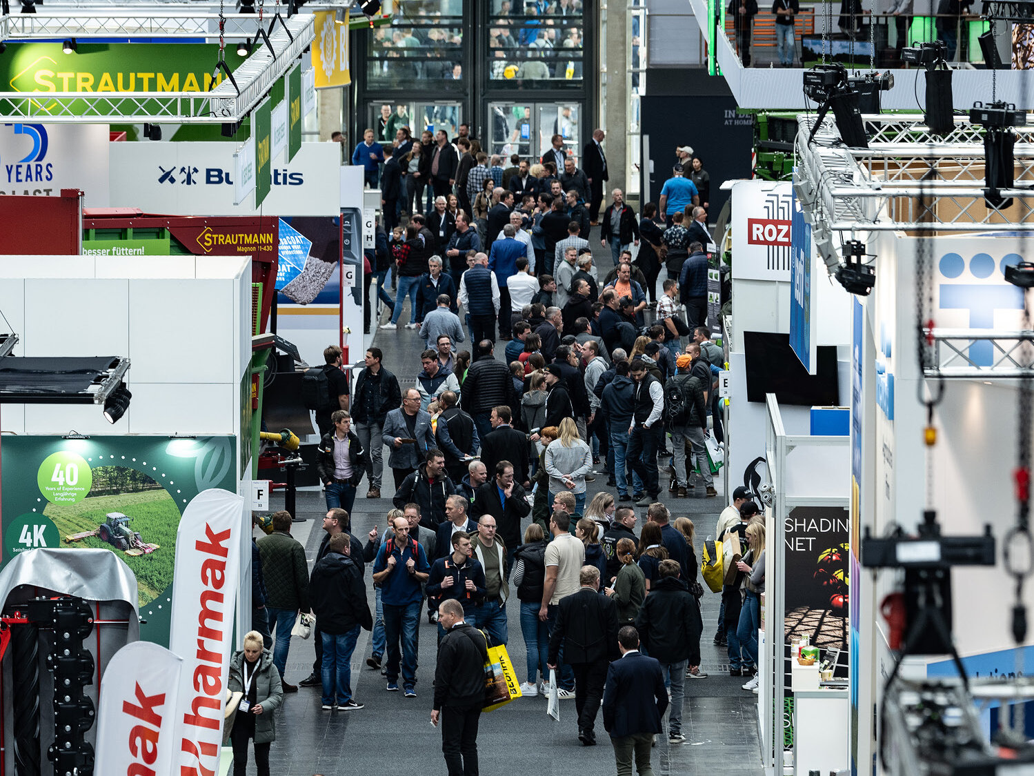 An aerial view image of a crowded agricultural machinery exhibition hall filled with visitors.